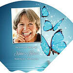 Memorial card with a smiling woman's photo and blue butterflies for remembrance.