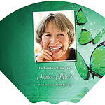 Memorial fan with a photo of a smiling woman and green butterflies.